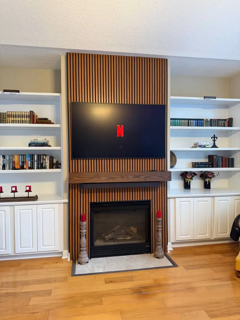 Completed wood panel accent wall with fireplace and mounted TV in Jacksonville, FL